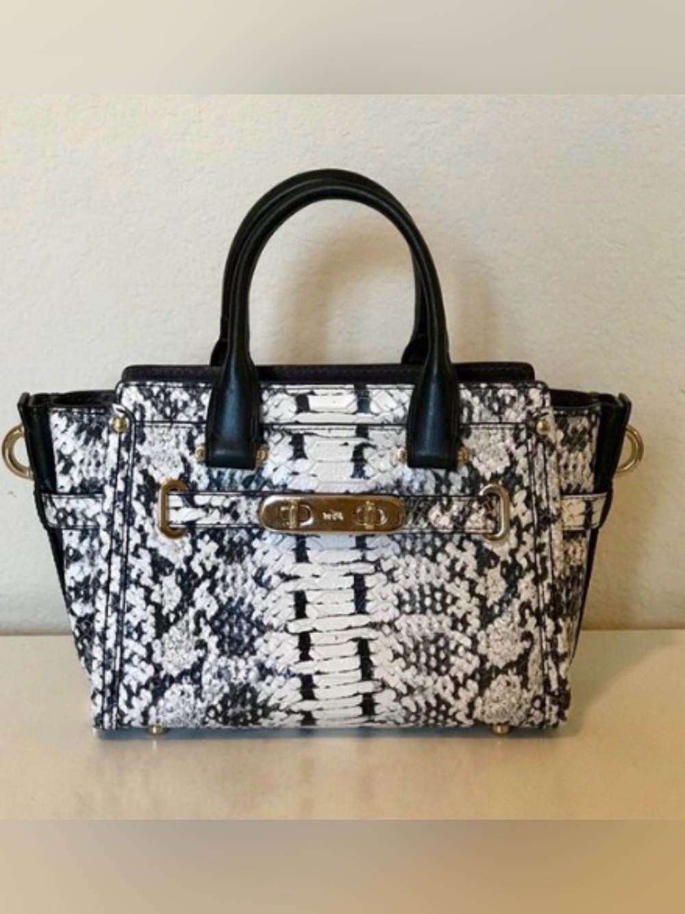 Coach Swagger 27 satchel in a black and white snake-embossed leather pattern.